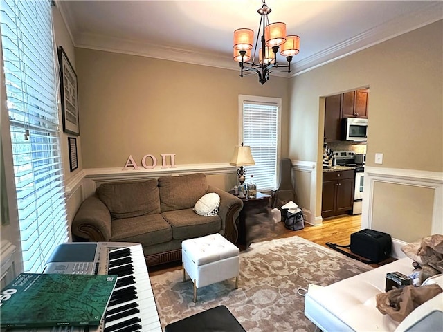 living room with ornamental molding, light hardwood / wood-style flooring, a healthy amount of sunlight, and a notable chandelier