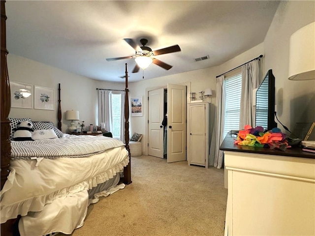 carpeted bedroom with multiple windows and ceiling fan