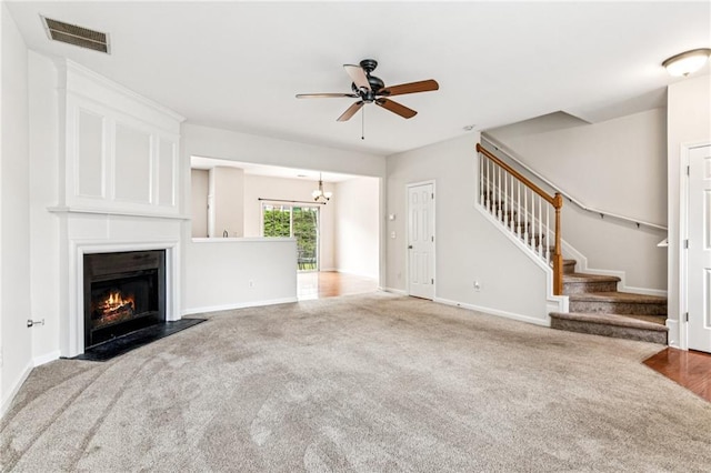 1049 Prestwyck Ct, Alpharetta, GA 30004 - unfurnished living room with carpet, a ceiling fan, stairs, a fireplace with flush hearth, and a chandelier