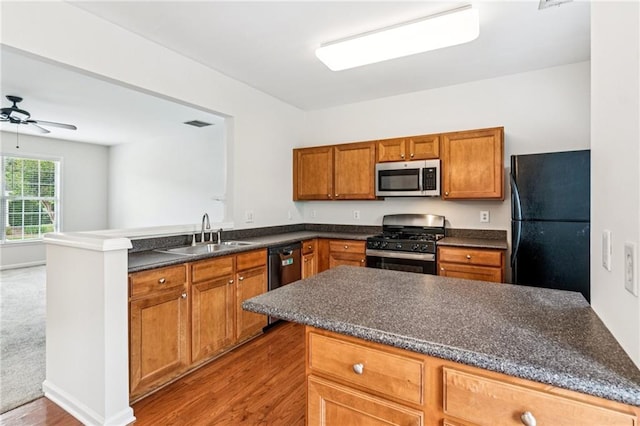 1049 Prestwyck Ct, Alpharetta, GA 30004 - kitchen featuring stainless steel microwave, gas range oven, freestanding refrigerator, a peninsula, and dark countertops