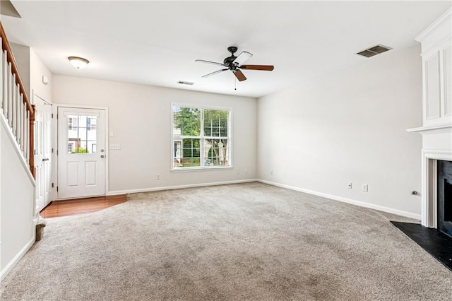 1049 Prestwyck Ct, Alpharetta, GA 30004 - unfurnished living room with carpet, stairs, a ceiling fan, and a fireplace with flush hearth