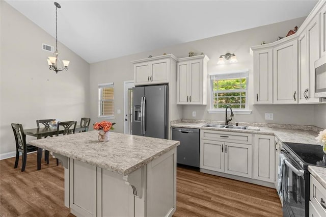 417 Beamer Rd SW, Calhoun, GA 30701 - kitchen with stainless steel appliances, a sink, dark wood-type flooring, vaulted ceiling, and a kitchen island