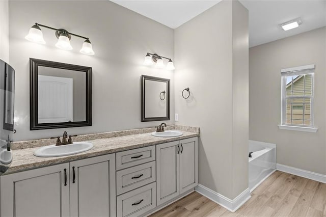 417 Beamer Rd SW, Calhoun, GA 30701 - bathroom with baseboards, wood finished floors, double vanity, and a garden tub