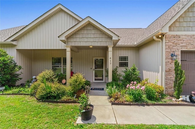 417 Beamer Rd SW, Calhoun, GA 30701 - property entrance featuring a shingled roof, a porch, a garage, stone siding, and a lawn