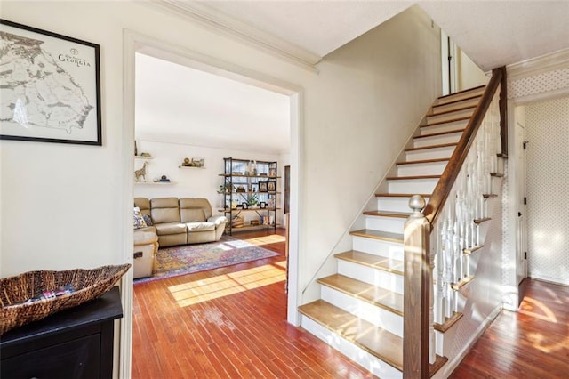 stairs featuring hardwood / wood-style flooring and ornamental molding