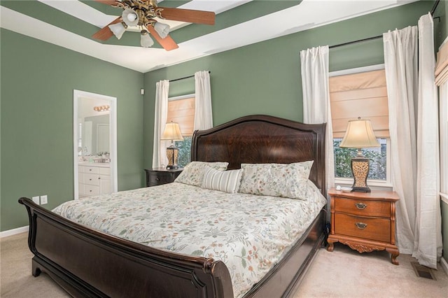 bedroom with ensuite bath, multiple windows, carpet flooring, and baseboards