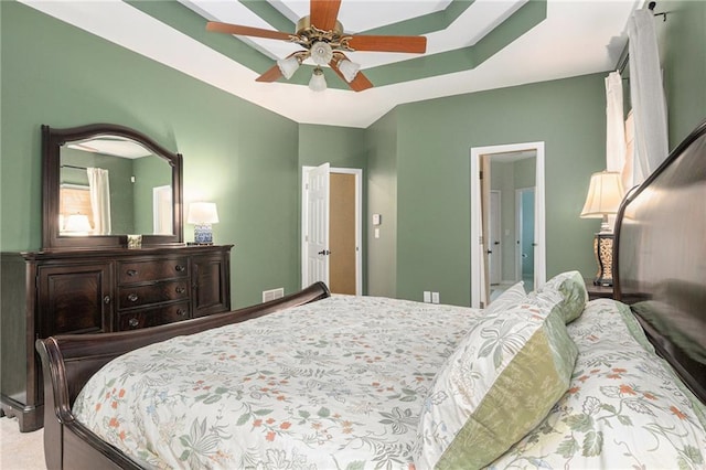 bedroom with visible vents, ceiling fan, and a tray ceiling