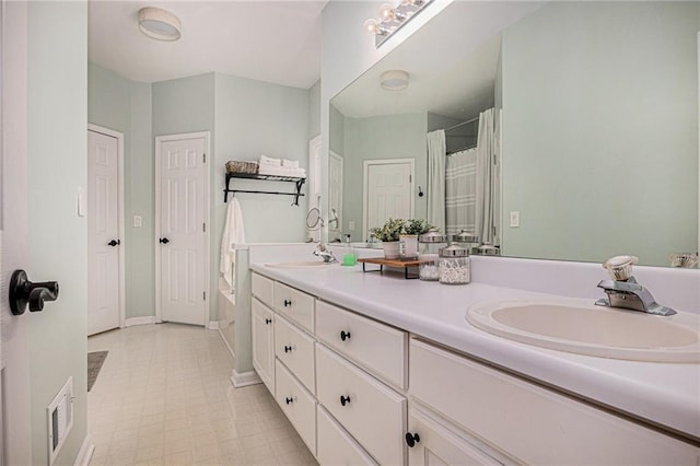 full bath featuring a sink, visible vents, double vanity, and tile patterned floors