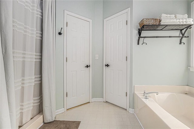 full bath with a shower with shower curtain, a garden tub, baseboards, and tile patterned floors