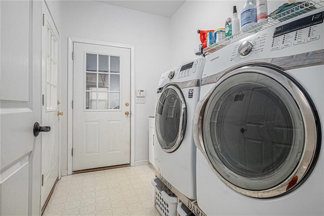 laundry room with laundry area, washing machine and dryer, baseboards, and light floors