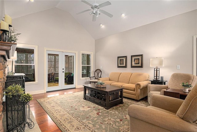 living area with a ceiling fan, wood finished floors, baseboards, high vaulted ceiling, and french doors