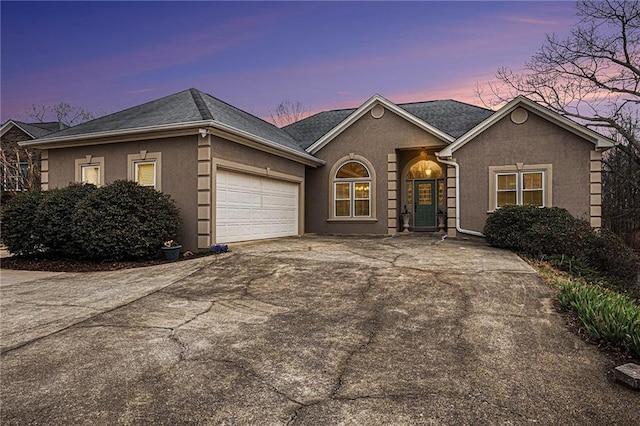 ranch-style house with stucco siding, driveway, and a garage