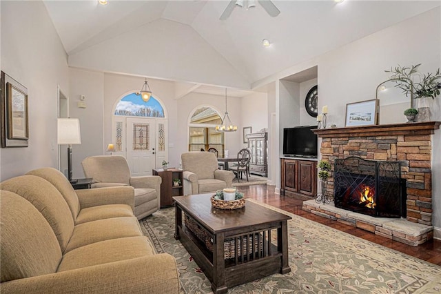 living room with a stone fireplace, ceiling fan with notable chandelier, high vaulted ceiling, and wood finished floors