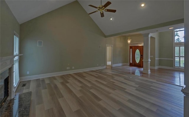 2121 Brittany Ct, Gainesville, GA 30506 - unfurnished living room with high vaulted ceiling, ceiling fan, a high end fireplace, decorative columns, and wood finished floors