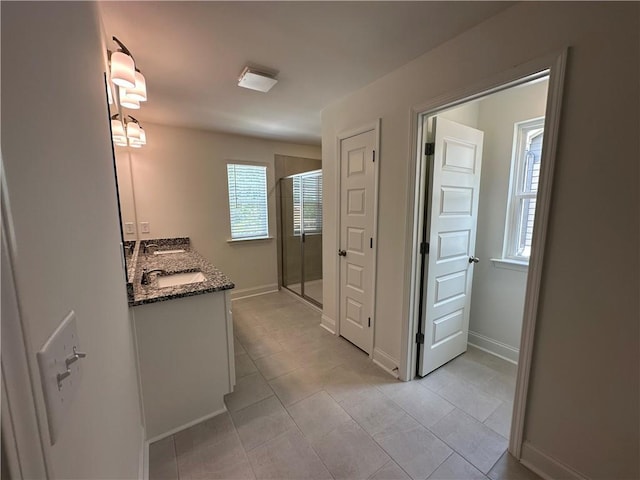 full bathroom featuring vanity, tile patterned floors, baseboards, and a stall shower