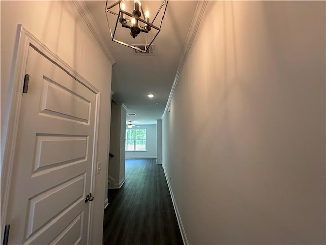 hall featuring dark wood-style flooring, crown molding, baseboards, a notable chandelier, and recessed lighting