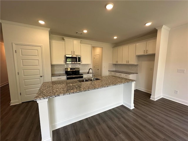 kitchen featuring a sink, dark stone counters, stainless steel appliances, baseboards, and dark wood-type flooring