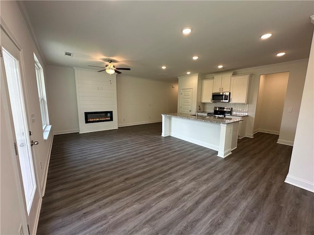 kitchen with stainless steel appliances, baseboards, a ceiling fan, and white cabinetry