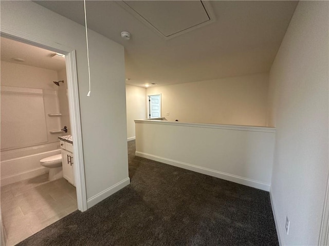 interior space with baseboards and dark colored carpet