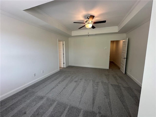 carpeted spare room featuring ceiling fan, visible vents, crown molding, baseboards, and a tray ceiling