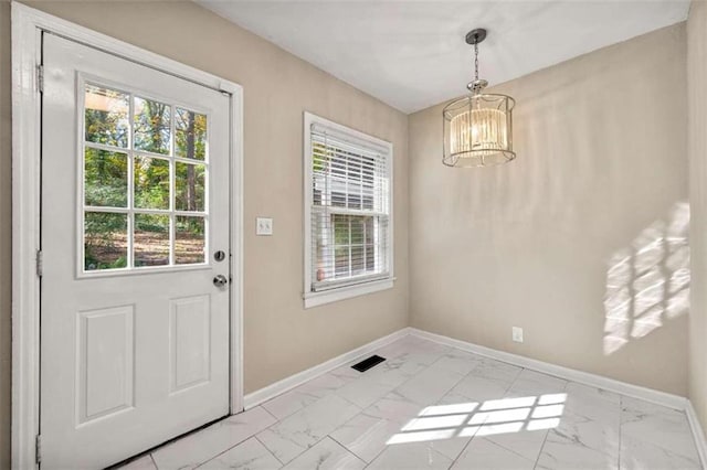 doorway featuring a notable chandelier