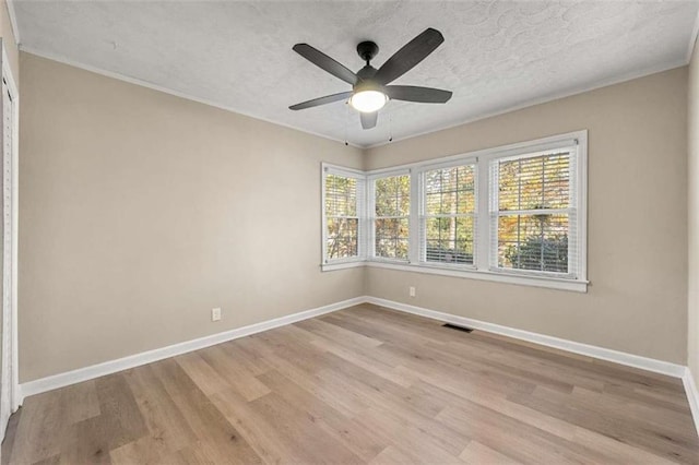 unfurnished room featuring plenty of natural light, light hardwood / wood-style floors, a textured ceiling, and ceiling fan