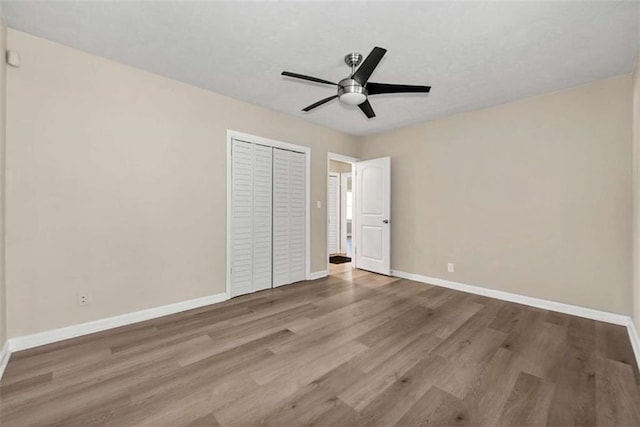 unfurnished bedroom featuring light wood-type flooring, a closet, and ceiling fan