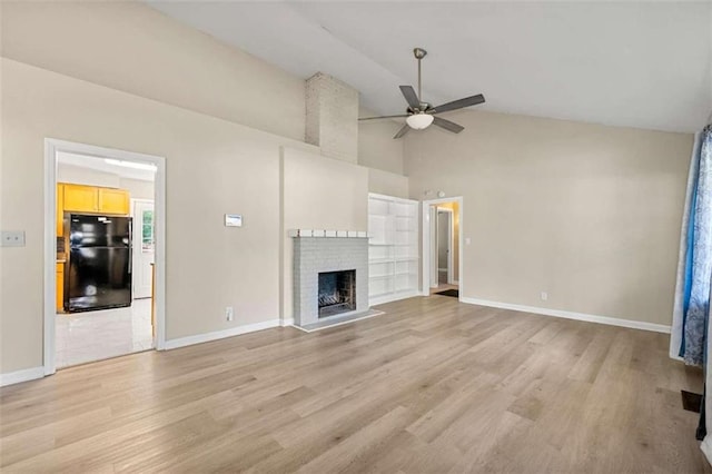 unfurnished living room with built in shelves, ceiling fan, light hardwood / wood-style flooring, high vaulted ceiling, and a fireplace