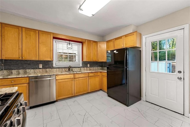 kitchen with appliances with stainless steel finishes, backsplash, light stone counters, sink, and pendant lighting