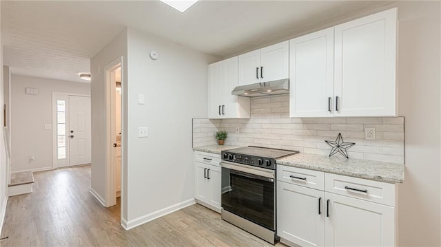 kitchen featuring tasteful backsplash, light wood-style floors, white cabinetry, stainless steel range with electric stovetop, and under cabinet range hood