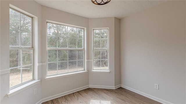 unfurnished room featuring baseboards and wood finished floors