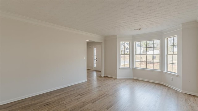 spare room with crown molding, a textured ceiling, and wood finished floors