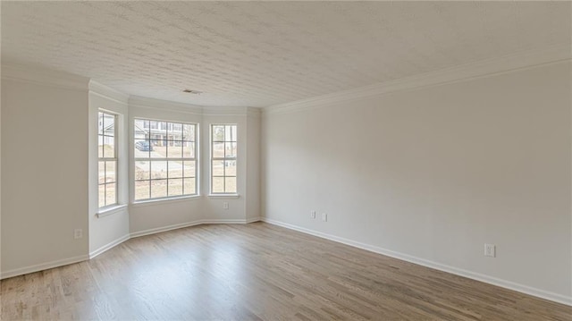 unfurnished room featuring crown molding, baseboards, and wood finished floors