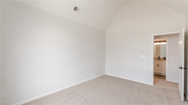 unfurnished room featuring visible vents, vaulted ceiling, light carpet, and baseboards