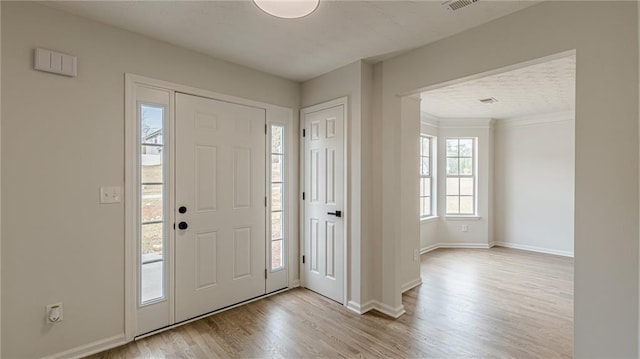 entryway featuring visible vents, baseboards, and wood finished floors