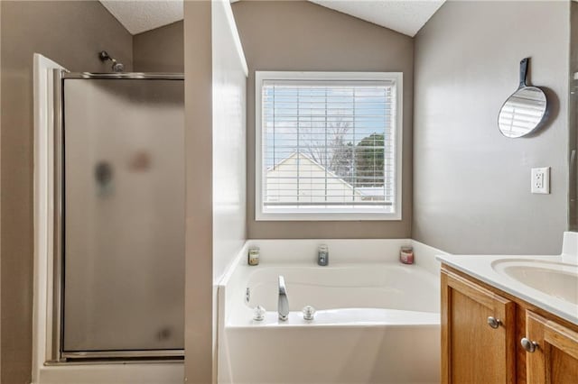 bathroom featuring independent shower and bath, vanity, vaulted ceiling, and a textured ceiling