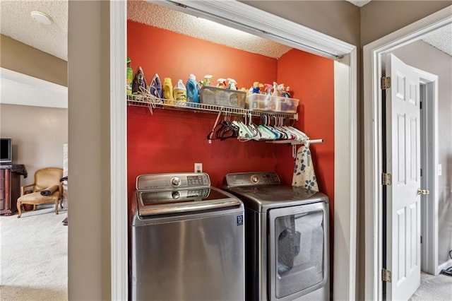 washroom with carpet flooring, washing machine and dryer, and a textured ceiling