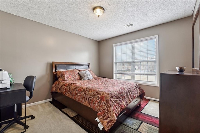 bedroom with light colored carpet and a textured ceiling