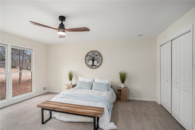 bedroom featuring light carpet, ceiling fan, and a closet