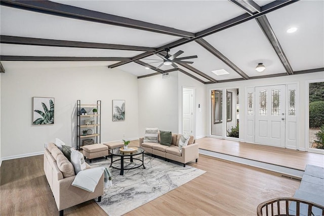 living room with hardwood / wood-style flooring, vaulted ceiling with beams, and ceiling fan