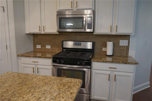 kitchen featuring tasteful backsplash, appliances with stainless steel finishes, stone counters, and white cabinets