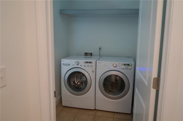 laundry room with laundry area, light tile patterned flooring, and washing machine and clothes dryer