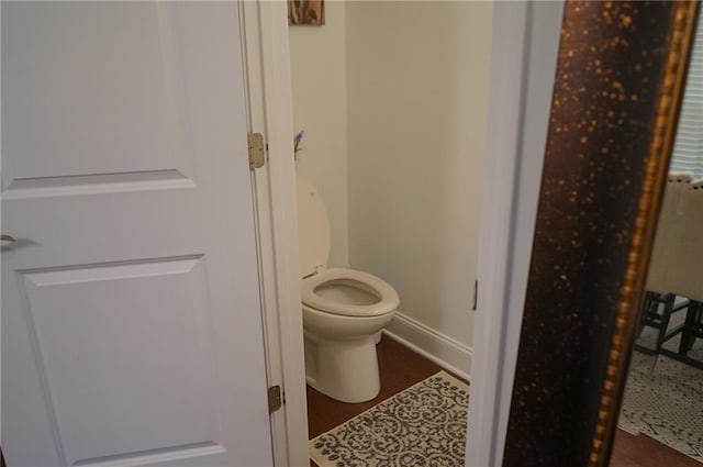 bathroom with toilet and baseboards