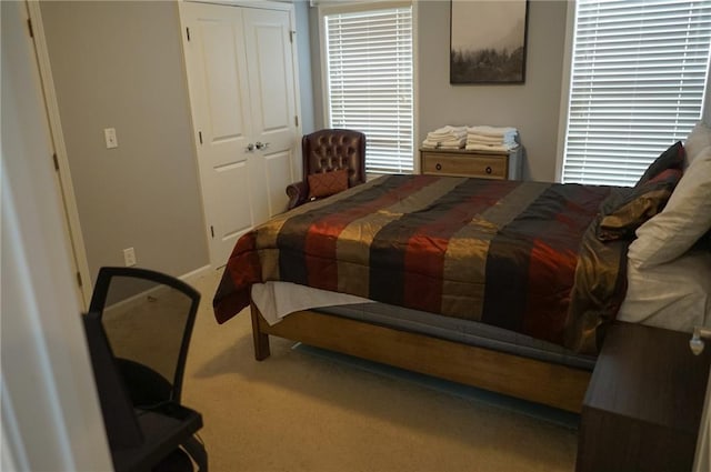 bedroom featuring carpet, a closet, and baseboards