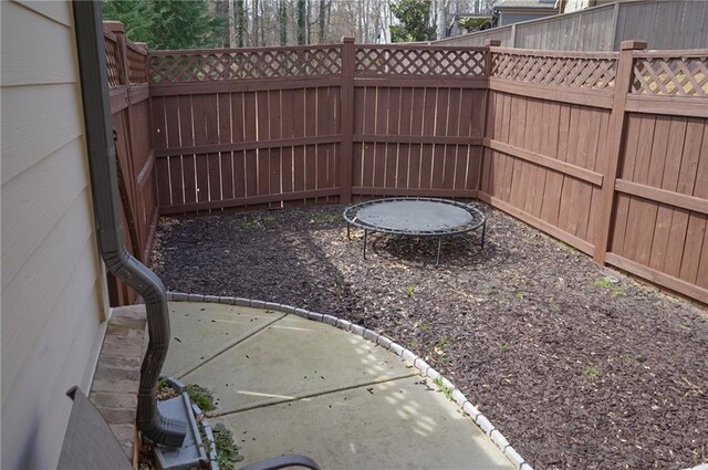 view of yard featuring a trampoline and a fenced backyard