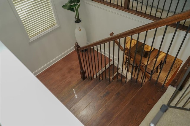 stairs with wood finished floors and baseboards