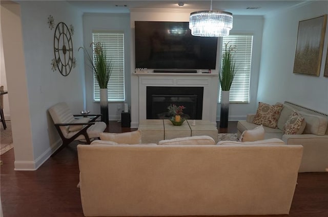 living room featuring baseboards, dark wood-style floors, an inviting chandelier, crown molding, and a fireplace