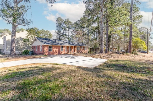 back of property with a lawn and concrete driveway