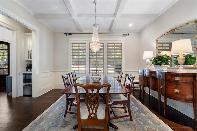 dining room with a wainscoted wall, beam ceiling, coffered ceiling, wood finished floors, and an inviting chandelier