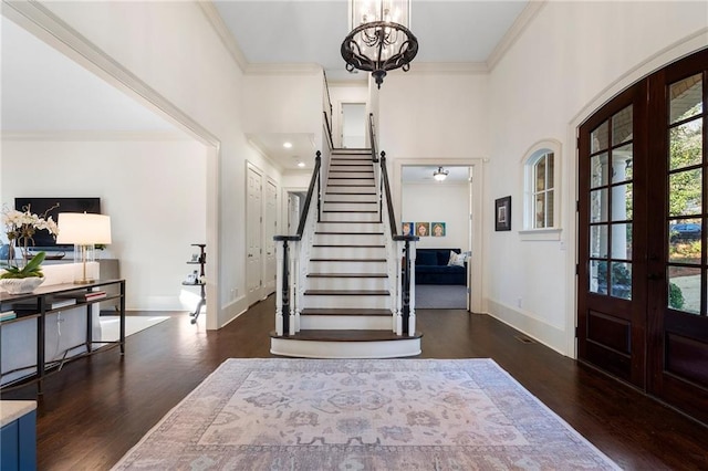 entrance foyer featuring wood finished floors, french doors, and ornamental molding